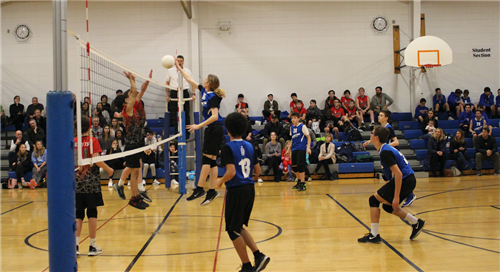 Student spiking ball in volleyball game 